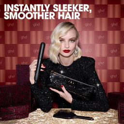 Woman holding a ghd hair straightener with text 'Instantly Sleeker, Smoother Hair' on a red checkered background.