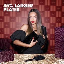 Woman holding a hair dryer with ghd branding in the background