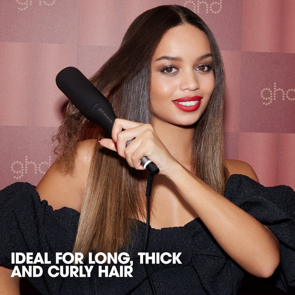 Woman using a hair straightener with text 'Ideal for long, thick and curly hair' on a pink background
