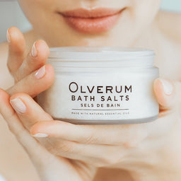 a women holds the Olverum Bath Salts close to her face