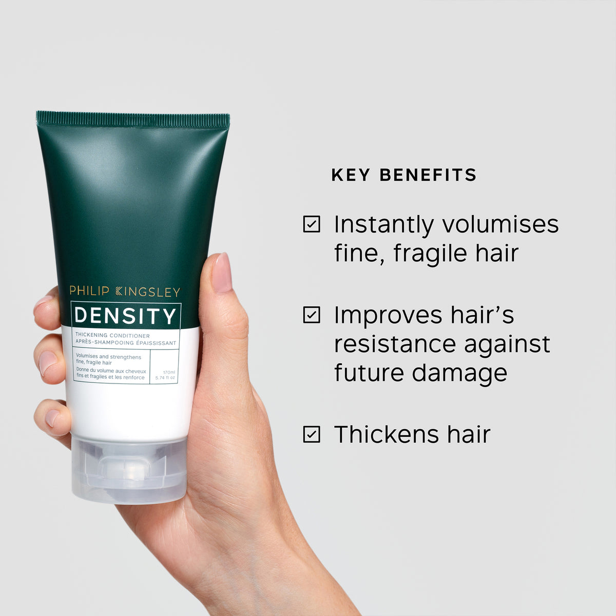 Hand holding a tube of Philip Kingsley Density hair product with key benefits listed.