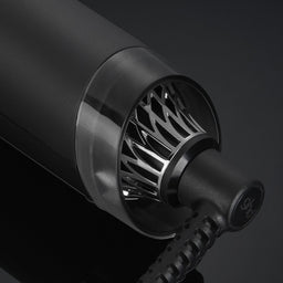 Close-up of a black hair dryer nozzle on a dark background