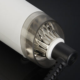 Close-up of a cylindrical electronic device with metallic and white components on a black background
