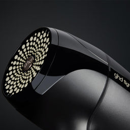 Black hair dryer with brand logo on a dark background