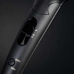 Black hair straightener with control buttons on a dark background