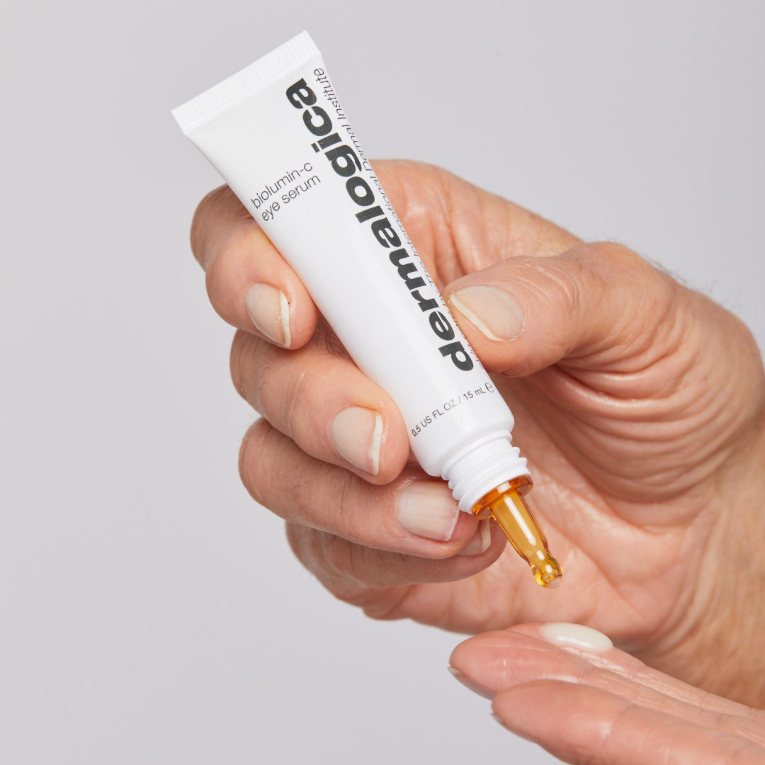 Hand holding a Dermalogica serum tube with a clear background