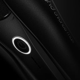 Close-up of a black electronic device with a circular component on a dark background