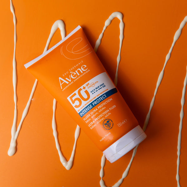 Avene sunscreen tube on an orange background