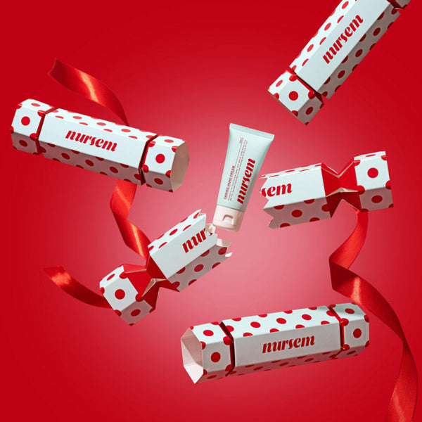 Several Mirren-branded cosmetic tubes and boxes with red polka dots and red ribbons floating against a solid red background.
