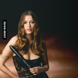 Woman holding a hair dryer against a dark background with 'Waves' branding.