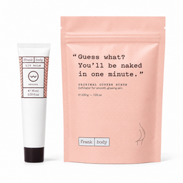 Frank Body exfoliator set featuring a white tube of lip balm with a black cap next to a large peach-pink stand-up pouch of Original Coffee Scrub, on a white background.