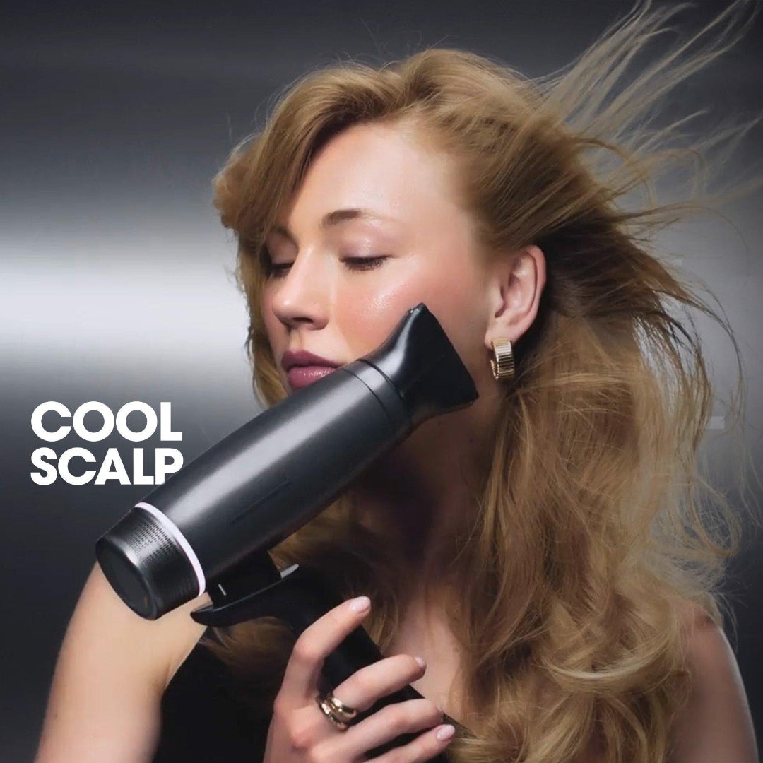 Woman using a hair dryer labeled 'Cool Scalp' on a dark background