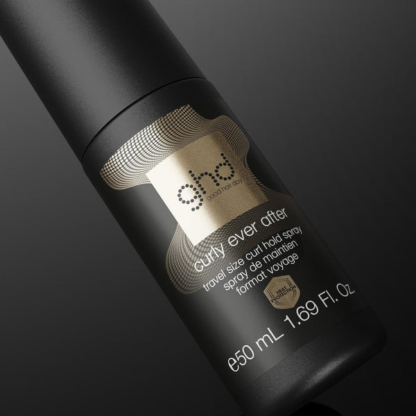 A black bottle of ghd Curl Ever Ever gel hair wax, angled diagonally on a dark gradient background. The bottle features a metallic gold label with the ghd logo and product details.