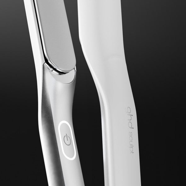 Close-up of a sleek white hair straightener with a metallic silver edge and a power button, set against a dark gradient background. The brand name 'hair of my life' is printed vertically on the handle.