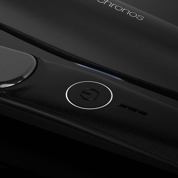 Close-up of a black electronic device with a circular power button, a glossy touch panel, and the word 'chronos' visible near the top.