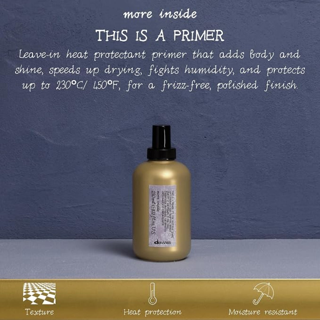 A bottle of d'Kuhnes hair primer centered on a gray surface against a textured blue-gray background, with white descriptive text above and a gold banner at the bottom highlighting texture, heat protection, and moisture resistance.