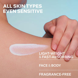 Close-up of a person's shoulder and hand with a smear of white cream on the skin, over a light blue background. White text reads: 'ALL SKIN TYPES EVEN SENSITIVE', 'LIGHT-WEIGHT & FAST-ABSORBING', 'FACE & BODY', and 'FRAGRANCE-FREE'.