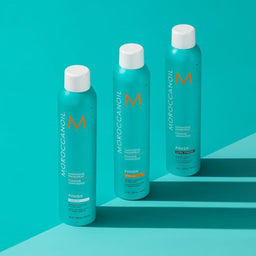 three bottles of Moroccanoil Luminous Hairspray Strong aligned next to each other