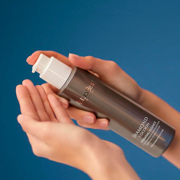 Natura Bisse Diamond Cocoon Hydrating Essence being poured into a hand