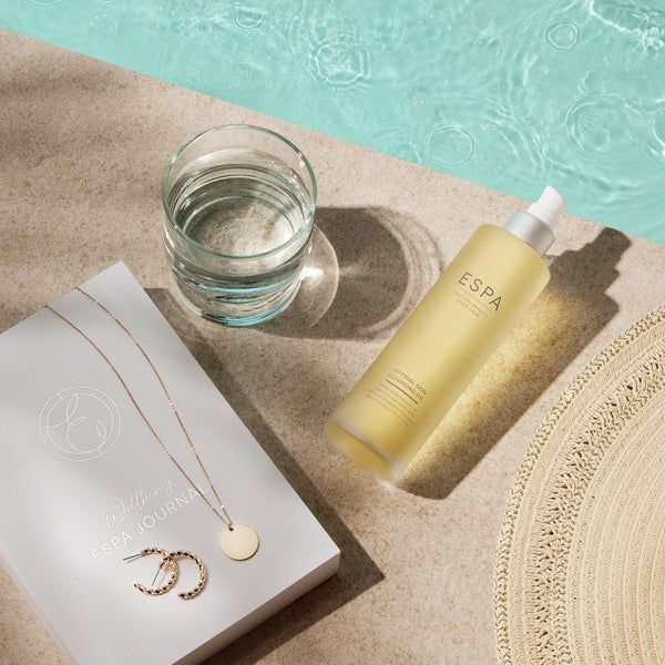 ESPA Optimal Skin Cleansing Oil bottle next to a pool 