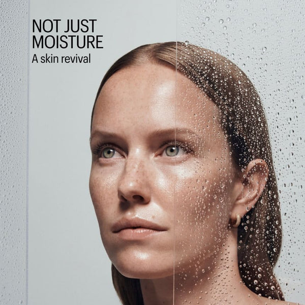 Woman with moisturized skin and water droplets, with text 'Not Just Moisture: A skin revival' on a gray background.