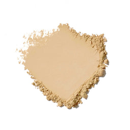 Heart-shaped pile of beige powder on a white background
