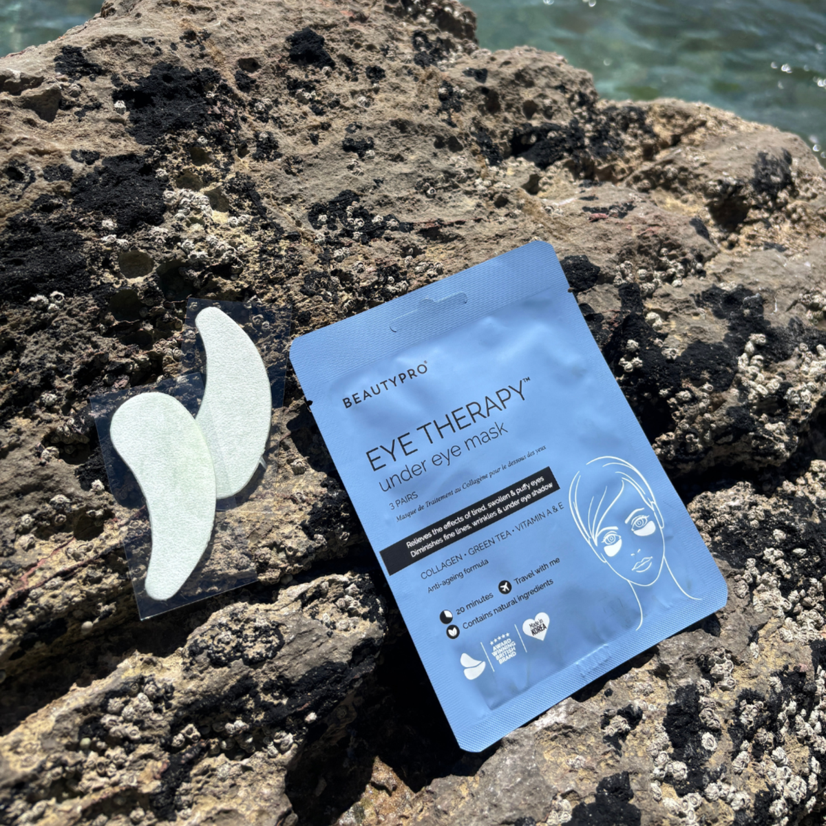 BEAUTYPRO eye therapy mask packaging on a rocky surface with ocean in the background