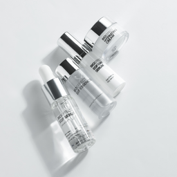 Skincare products including bottles and a tube on a light gray background