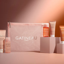 Gatineau skincare products displayed with a pink bag on a warm-toned background