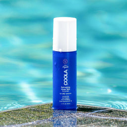 COOLA Daily Refreshing Mist SPF15 bottle next to a pool