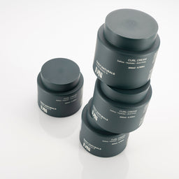 Three jars of Daily Naturals Curl Cream on a white background