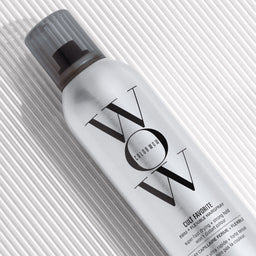 Hair spray bottle with 'VOX' branding on a textured white background