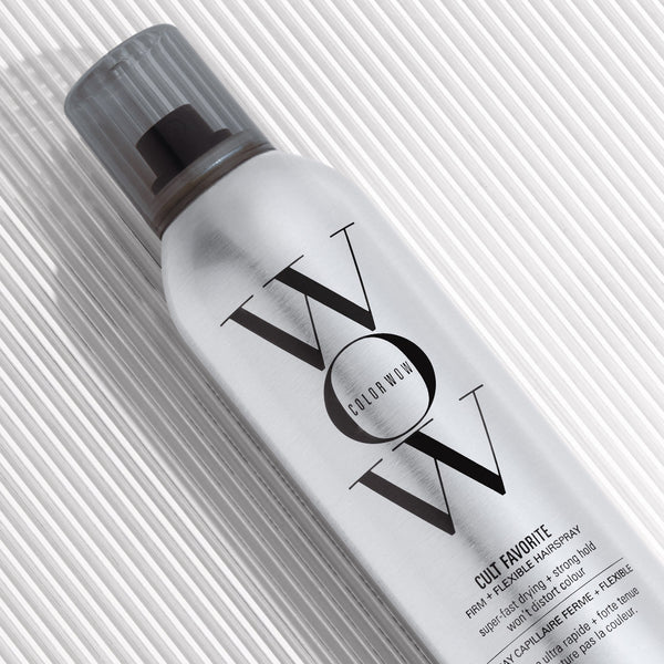Hair spray bottle with 'VOX' branding on a textured white background