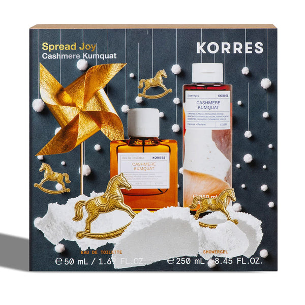 KORRES Spread Joy Cashmere Kumquat gift set featuring a matching shower gel and toilet bottle set in a festive dark gray box with gold rocking horses, a gold pinwheel, and white snow-like accents.