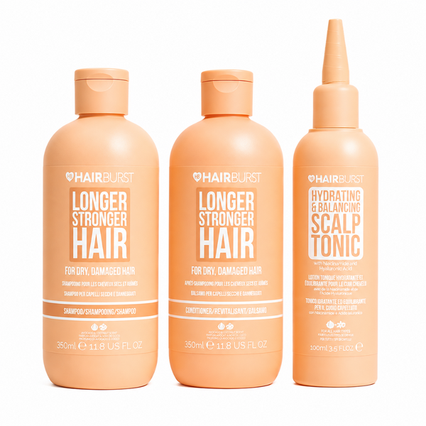 Three peach-colored Hairburst hair care bottles on a white background: Longer Stronger Hair shampoo, conditioner, and hydrating & balancing scalp tonic.