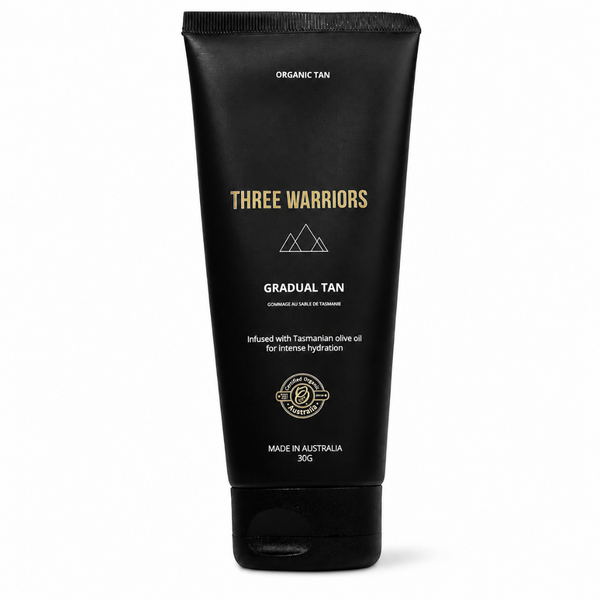 A 300g squeeze tube of Three Warriors Gradual Tan hair product in 'Organic Tan' shade, featuring a matte black tube with gold and white text, set against a plain white background.