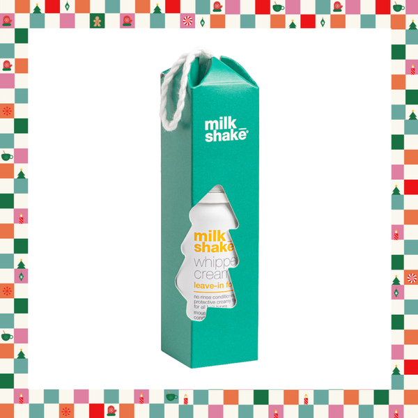 A teal Milk Shake Whip cream leave-in bottle carton with a white rope handle, shown on a white background with a colorful Christmas-themed border.