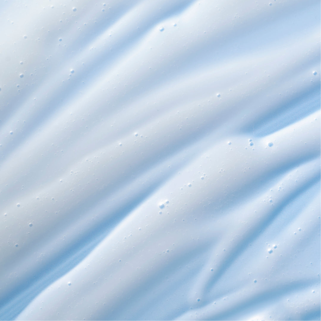 A close-up of a light blue and white textured surface with soft diagonal ridges and small dotted imperfections, resembling a smooth material swatch or fabric close-up.