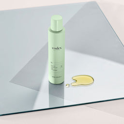 Codex Labs Bia Wash Off Cleansing Oil spray can on top of a glass slate