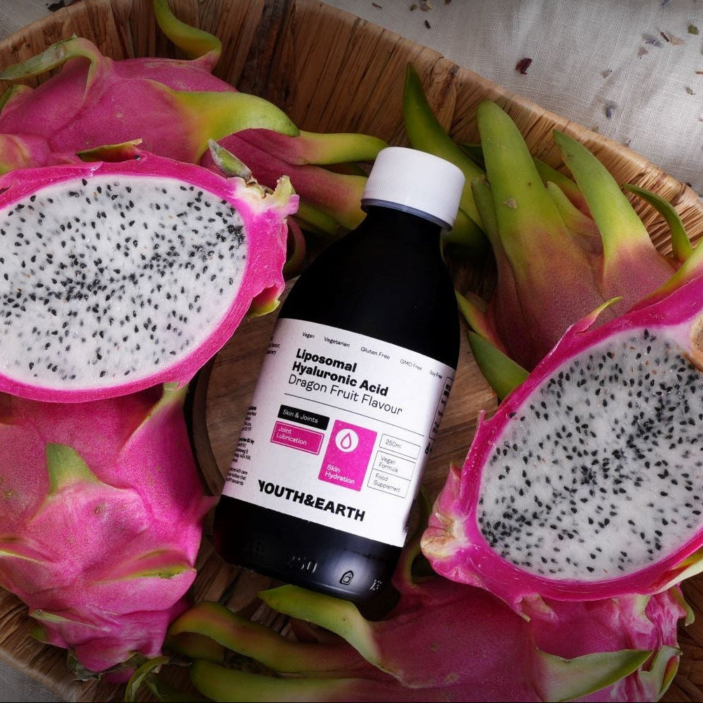A dark bottle labeled 'YOUTH&EARTH' and 'Lycopene Tomato Acid' placed in a woven basket with sliced dragon fruit and dried flowers. Large text reads 'Naturally Fuelling Your Longevity' and 'Subscribe & Save' with promotional bullet points.