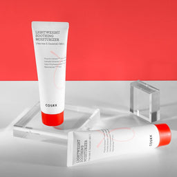 COSRX AC Collection Lightweight Soothing Moisturizer tubes on a white surface with red background