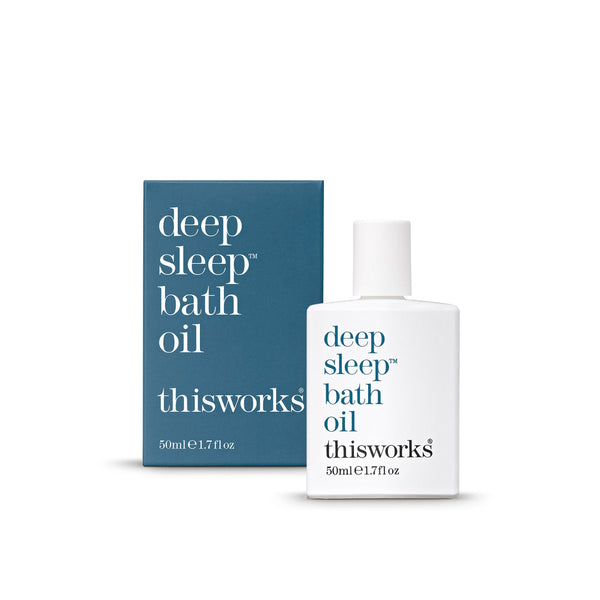 Thisworks Deep Sleep Bath Oil 50ml bottle next to its blue packaging box on a clean white background.