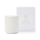 White candle with ribbed texture next to its packaging box on a white background
