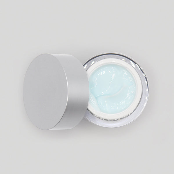 Cosmetic jar with light blue cream inside on a white background