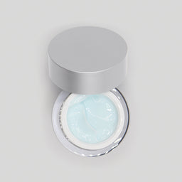Jar of light blue cream with a silver lid on a gray background