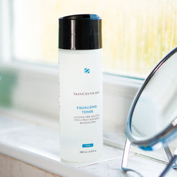 SkinCeuticals Equalizing Toner bottle on a bathroom windowsill 