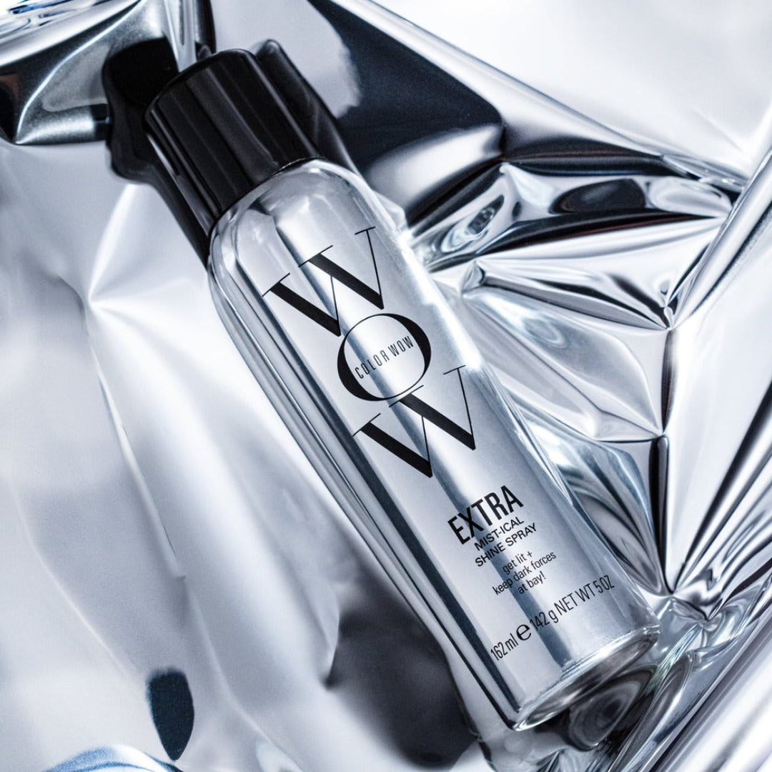 Color Wow Extra Shine Spray bottle on a metallic background