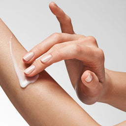 model applying the lotion to their arm