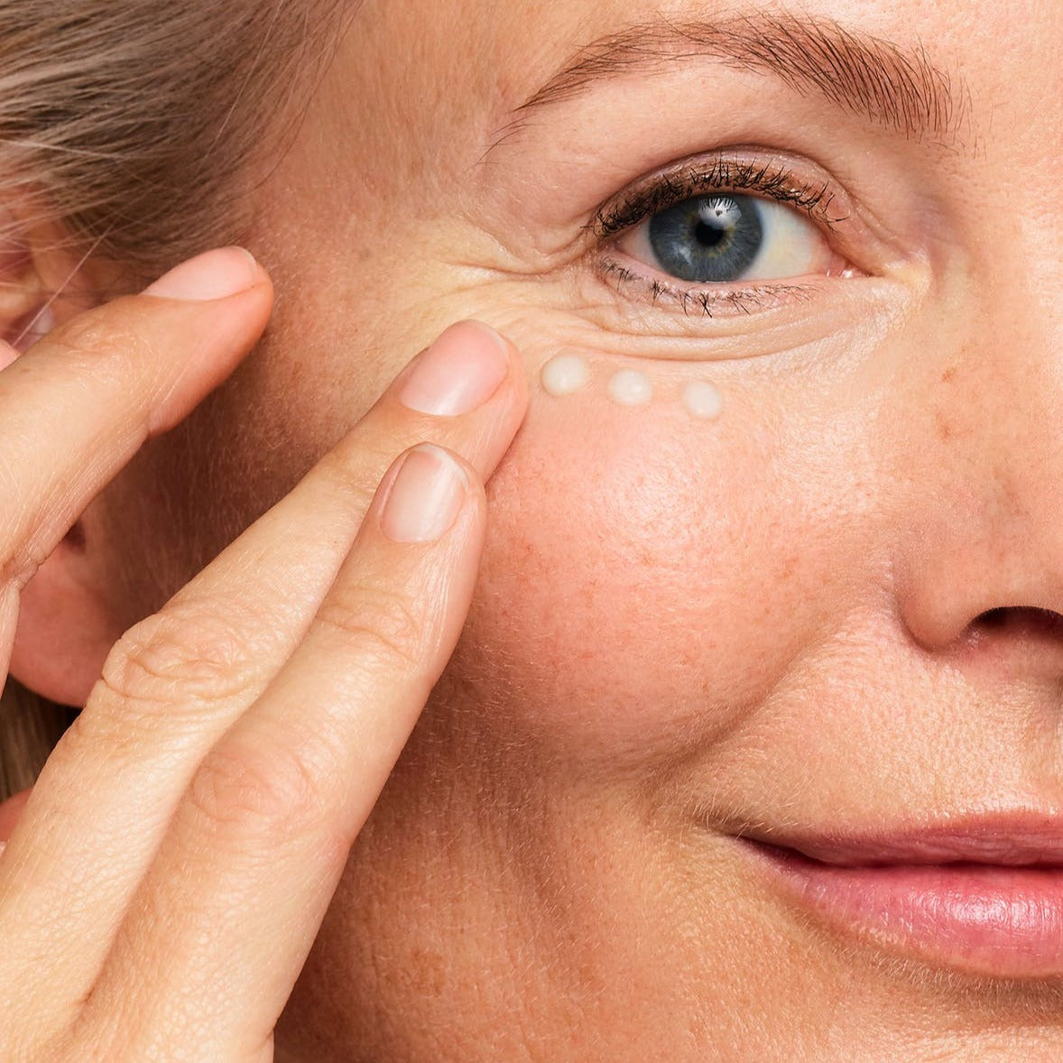 model applying the serum to her face