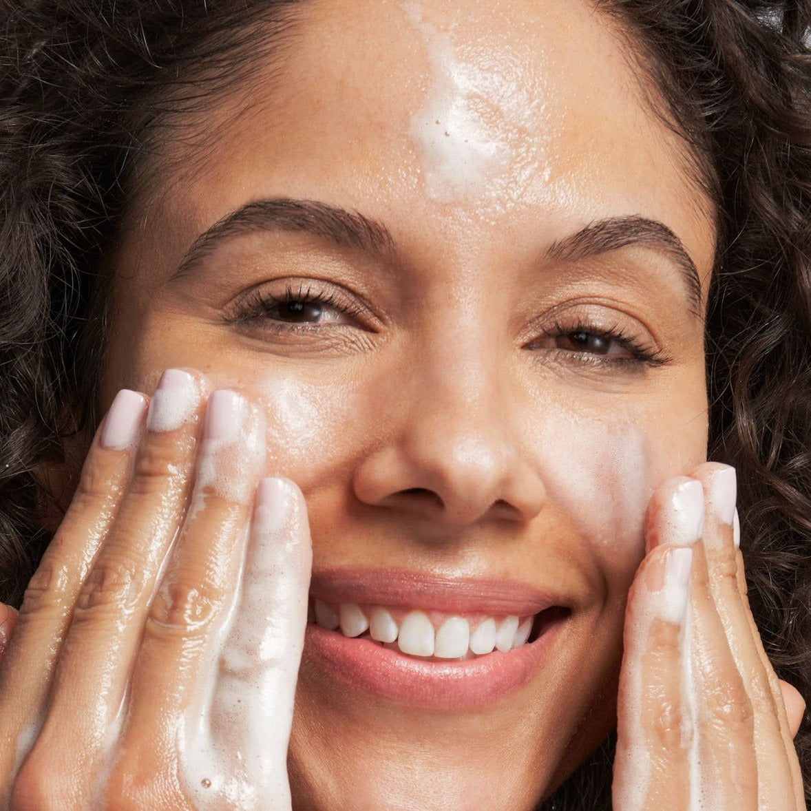 model applying the wash to her face